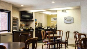 A breakfast area with a counter, a television, and a sign for 'Morning Medley Breakfast'. - Sleep Inn Florence North (Florence)