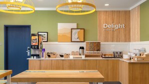 A modern kitchen with wooden cabinets, a coffee machine, and a sign that reads "Delight in the day". - Spark by Hilton El Paso University (El Paso)