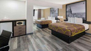 Een hotelkamer met twee bedden, een bureau met een magnetron en een stoel.