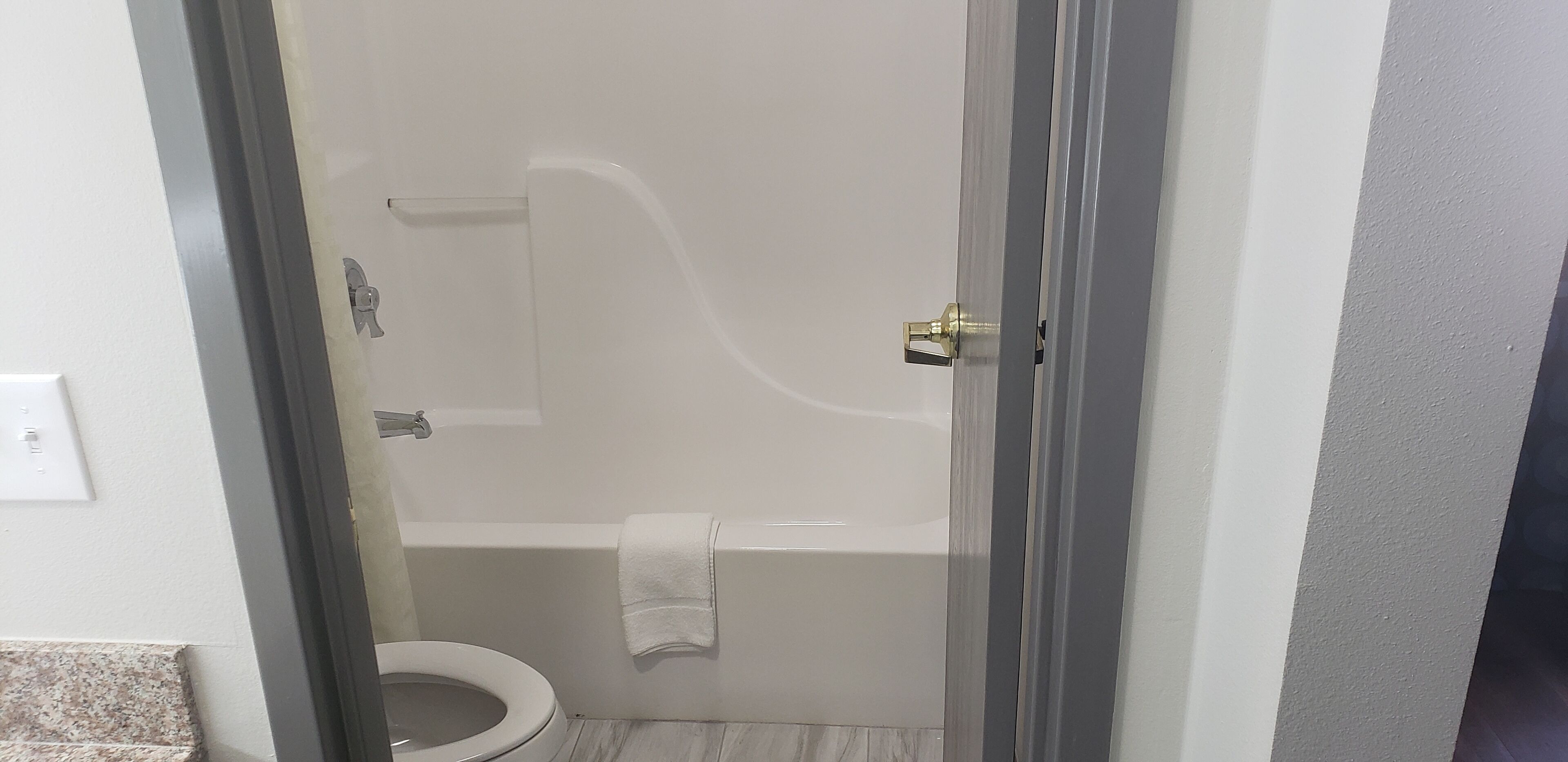 A bathroom with a toilet, a bathtub, and a shower.