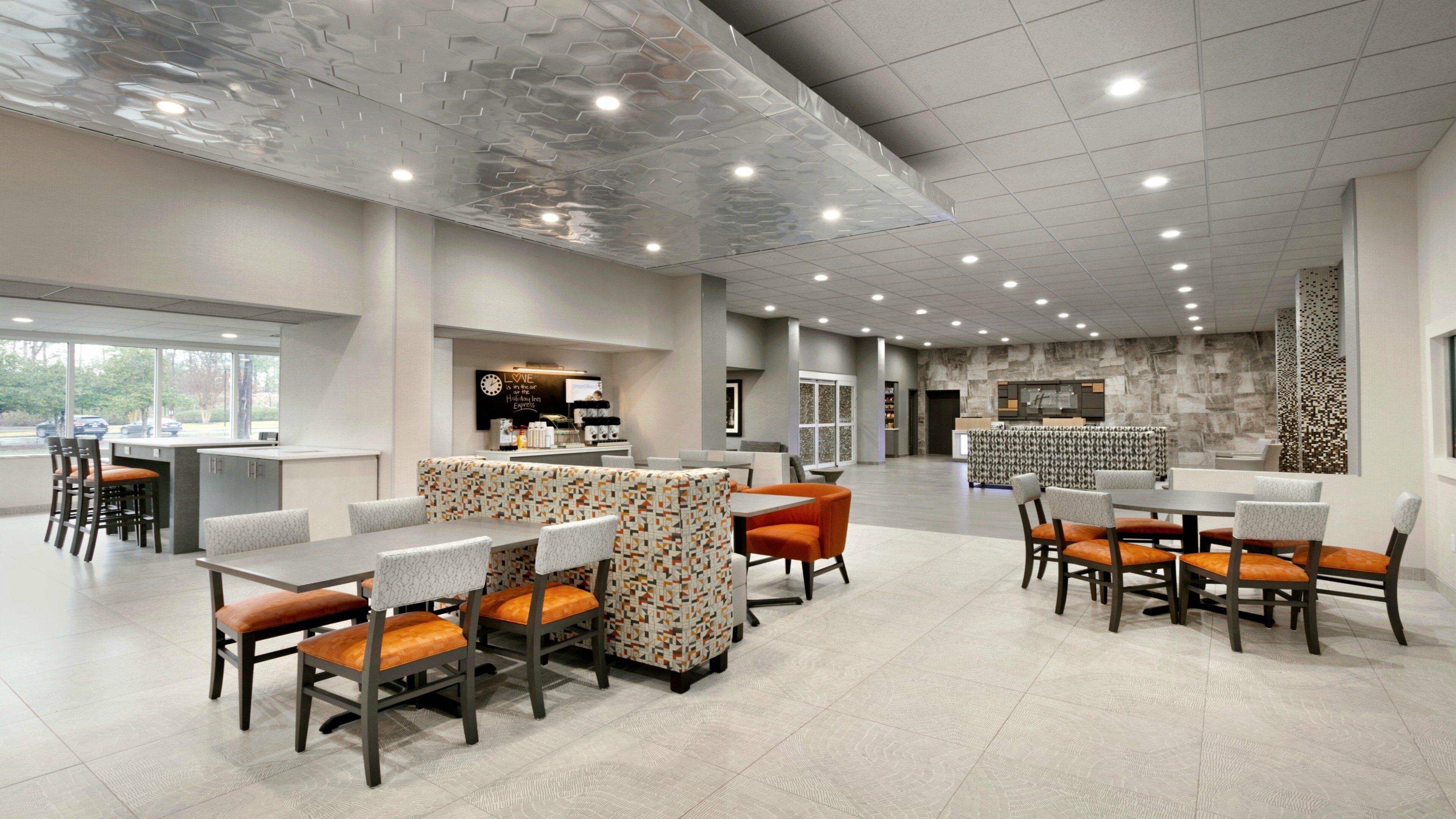 A spacious indoor area with multiple seating arrangements, a counter, and a view through large windows.