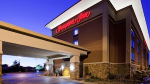A hotel entrance with a "Welcome" sign and a "Hampden Inn" sign.