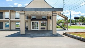 A modern building with a covered entrance, multiple parking spaces, and a clear sky. - Rodeway Inn Oxford (Oxford)