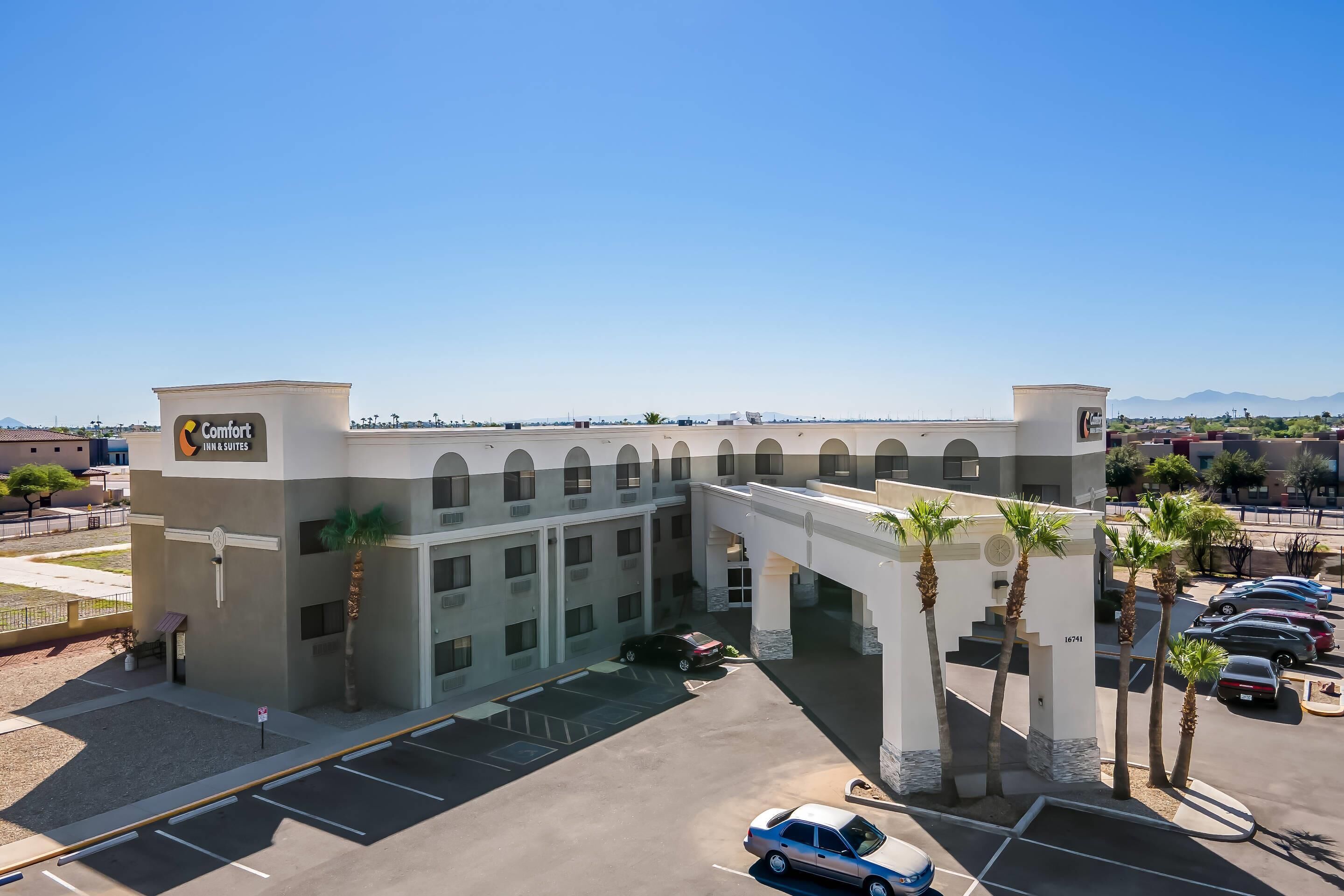 Un hôtel doté d’une entrée principale, de nombreux espaces de stationnement et offrant une vue dégagée sur les environs.