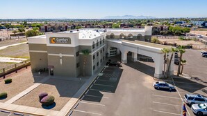 A Comfort Inn & Suites with a parking lot, a covered walkway, and a view of the surrounding area.