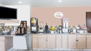 Een kitchenette met een koffieapparaat, broodrooster en een bordje voor een ontbijtrestaurant.