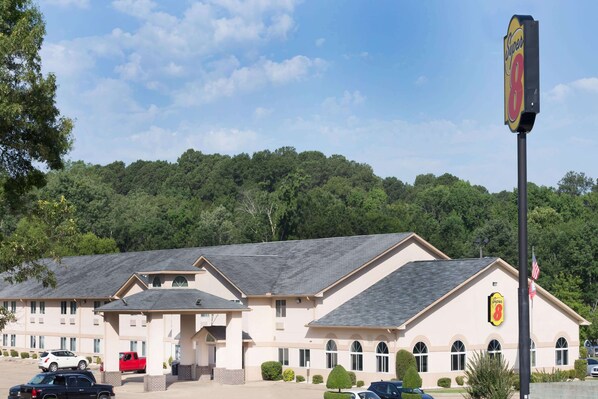 Un hôtel avec une grande enseigne indiquant « Super 8 » et un parking où sont garées plusieurs voitures.