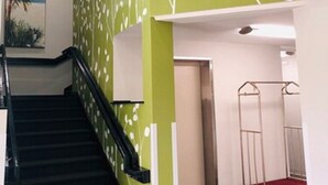 A staircase with a black handrail leading to a landing. - Hathaway Inn (Panama City)
