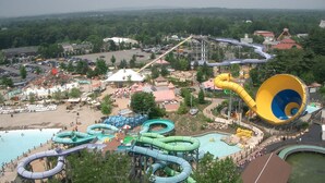 Parque acuático con múltiples toboganes y piscinas, rodeado de árboles y edificios.