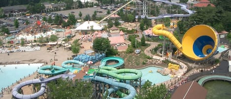 Parque acuático con múltiples toboganes y piscinas, rodeado de árboles y edificios.