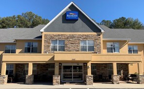Un bâtiment de la chaîne Baymont Inn & Suites, avec une façade en pierre, de nombreuses fenêtres et un ciel dégagé.