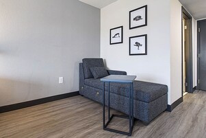 Una sala de estar moderna con un sofá gris, una mesita y tres cuadros enmarcados en la pared.