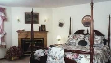 Un dormitorio con cama con dosel, una chimenea y un reloj en la pared.