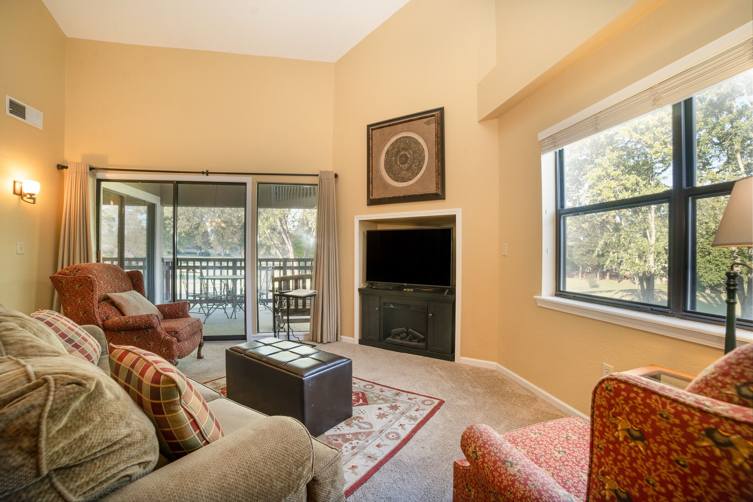 A living room with a fireplace, a sofa, a chair, and a TV.
