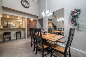 A dining area with a wooden table, black chairs, and a chandelier.