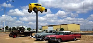 Een parkeerplaats met oldtimers en een sleepwagen.