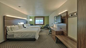 A hotel room with two beds, a desk, a TV, and a window with a view.