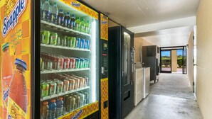 A Snapple vending machine stocked with various beverages and a refrigerator in a hallway. - Quality Inn Battleboro - Rocky Mount (Battleboro)