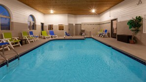 An indoor swimming pool with multiple lounge chairs and a slide. - Days Inn by Wyndham Sturtevant / Racine / Mount Pleasant (Mount Pleasant)