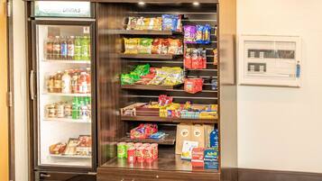 Máquina expendedora llena de bocadillos y bebidas, incluyendo marcas como Pepsi y productos de panadería.