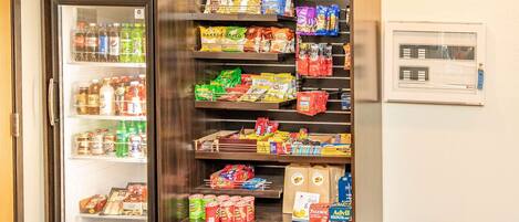 A vending machine stocked with snacks and drinks, including brands like Pepsi and baked snacks.