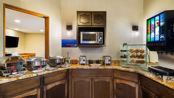 Una cocina de hotel con microondas, tostadora y menú digital.