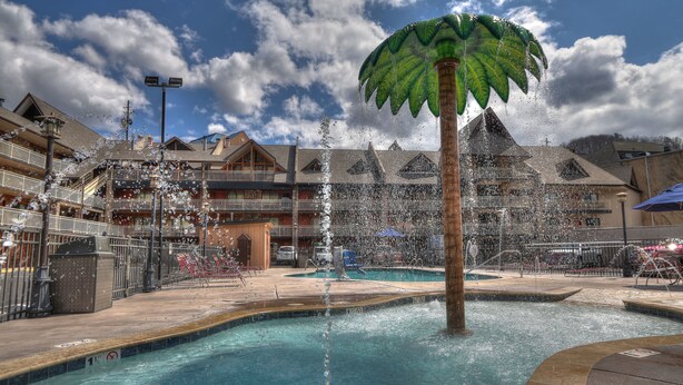 A pool area with a central water feature and a palm tree sculpture.