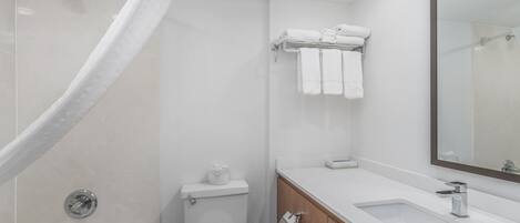 A modern bathroom with a bathtub, toilet, sink, and a mirror.