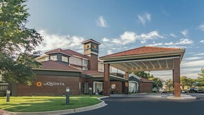 A hotel with a prominent entrance, a covered outdoor area, and a clear sky. - La Quinta Inn & Suites by Wyndham Alexandria Airport (Alexandria)