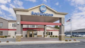 Un hôtel Best Western, reconnaissable à son enseigne bien visible, son entrée abritée et son parking où sont stationnées plusieurs voitures.