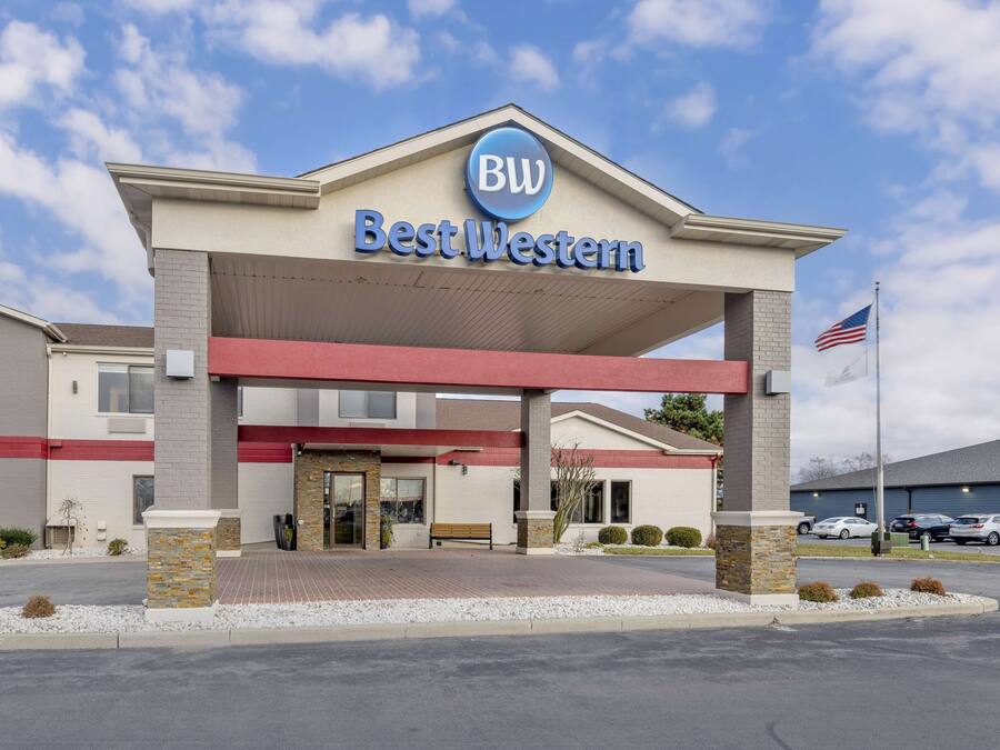 Un hôtel Best Western, reconnaissable à son enseigne bien visible, son entrée abritée et son parking où sont stationnées plusieurs voitures.