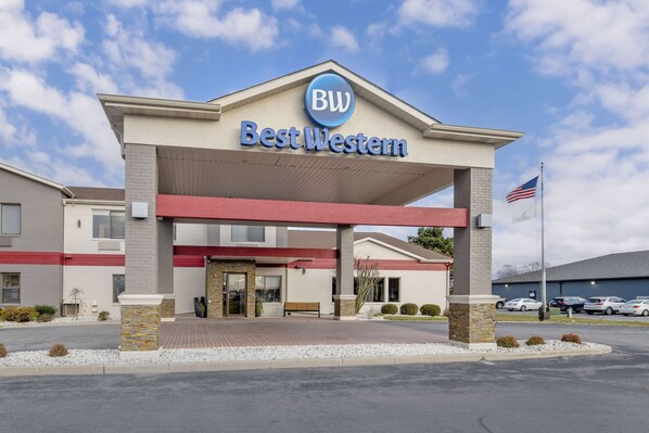 A Best Western hotel with a prominent sign, a covered entrance, and a parking lot with several cars.