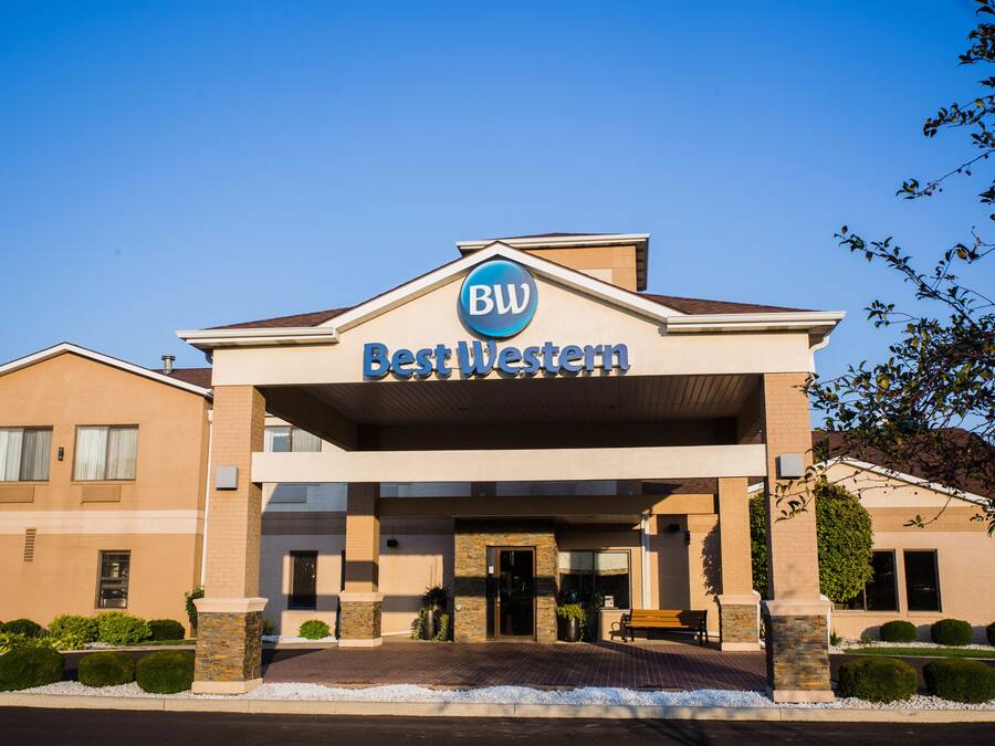 Fachada de un hotel Best Western con cielo despejado, un letrero sobre la entrada y un camino de acceso pavimentado.
