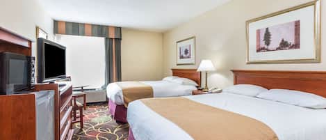 A hotel room with two beds, a television, a desk, and a large window.