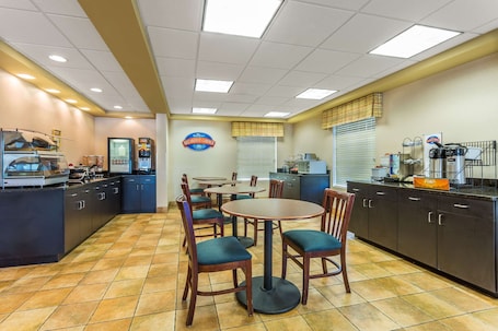 A breakfast diner with a counter, seating area, and kitchen.
