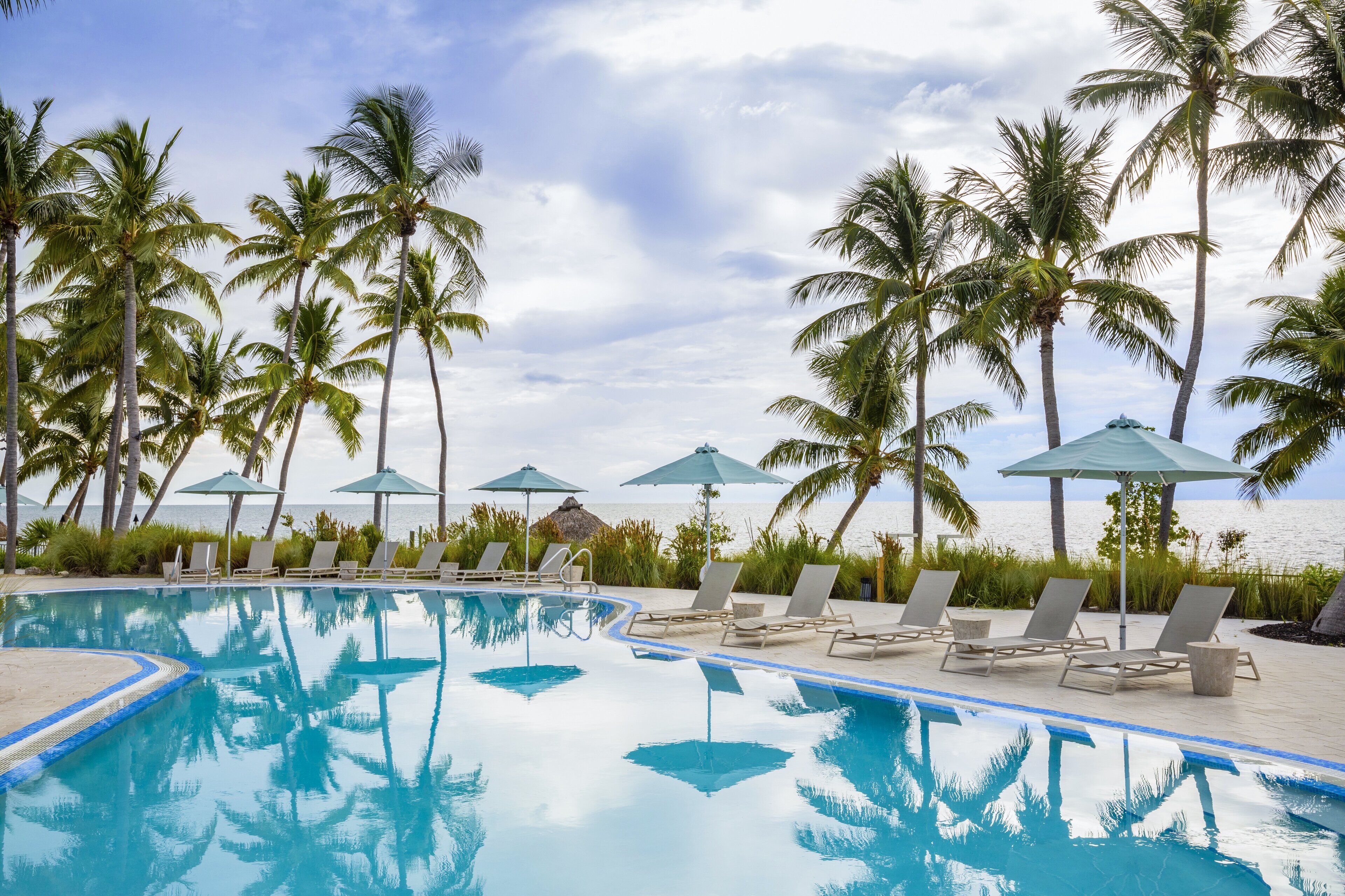 Een buitenzwembad, parasols bij het zwembad en ligstoelen