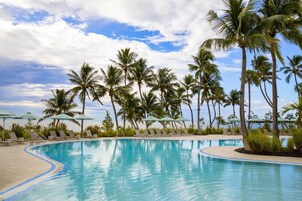 Una piscina al aire libre, sombrillas, sillones reclinables de piscina