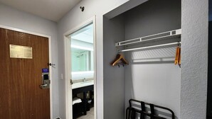 A bathroom with a wooden door, a towel rack, and a towel dispenser. - Motel 6 Pine Bluff, AR (Pine Bluff)