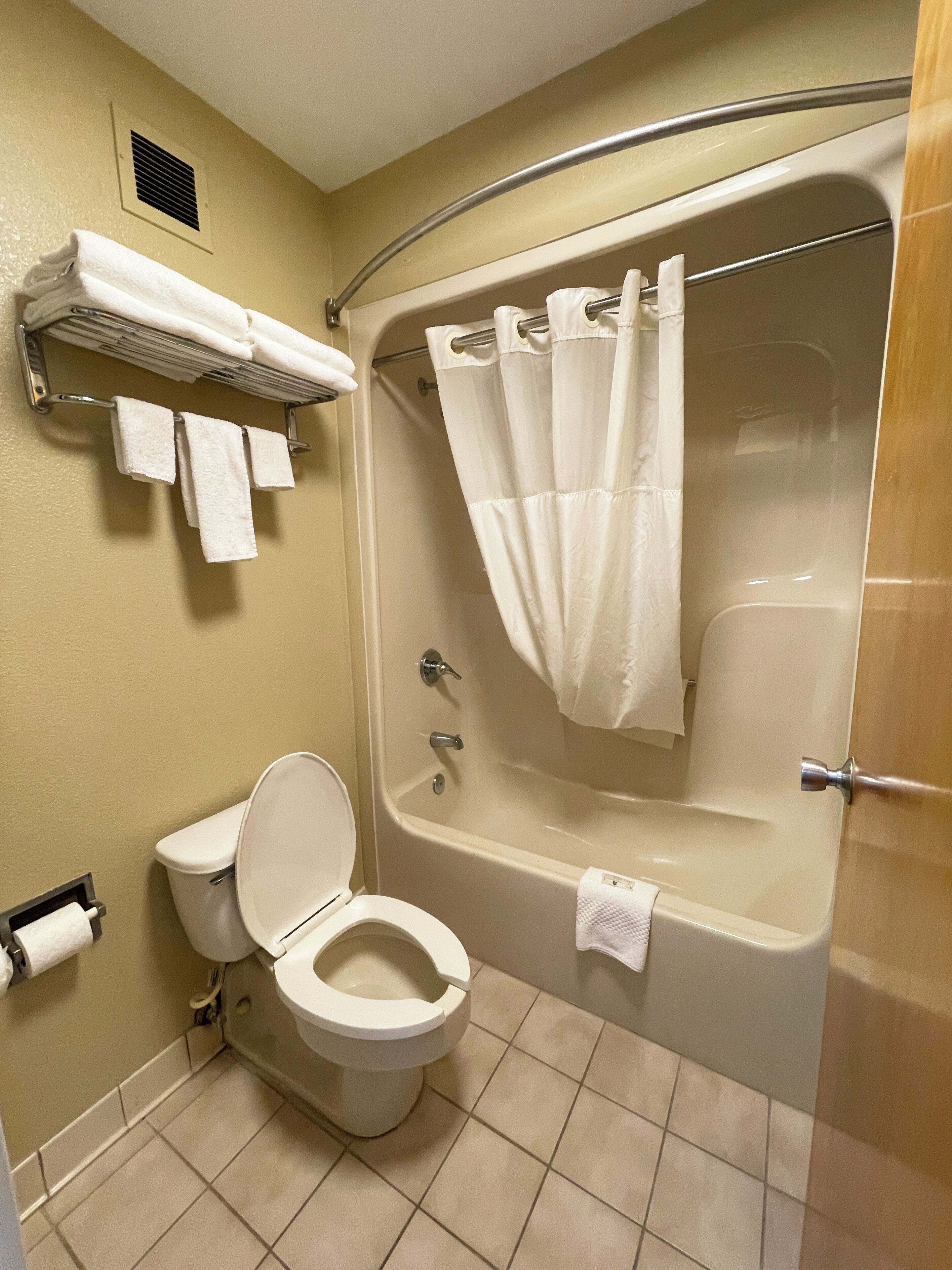 Un baño con inodoro, bañera y cortina de ducha.