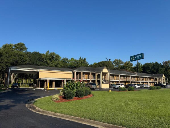Guests enter through the central entrance, leading to a covered walkway and parking area.