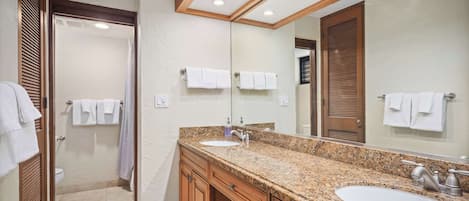 Une salle de bain avec deux lavabos, un grand miroir et des meubles en bois.