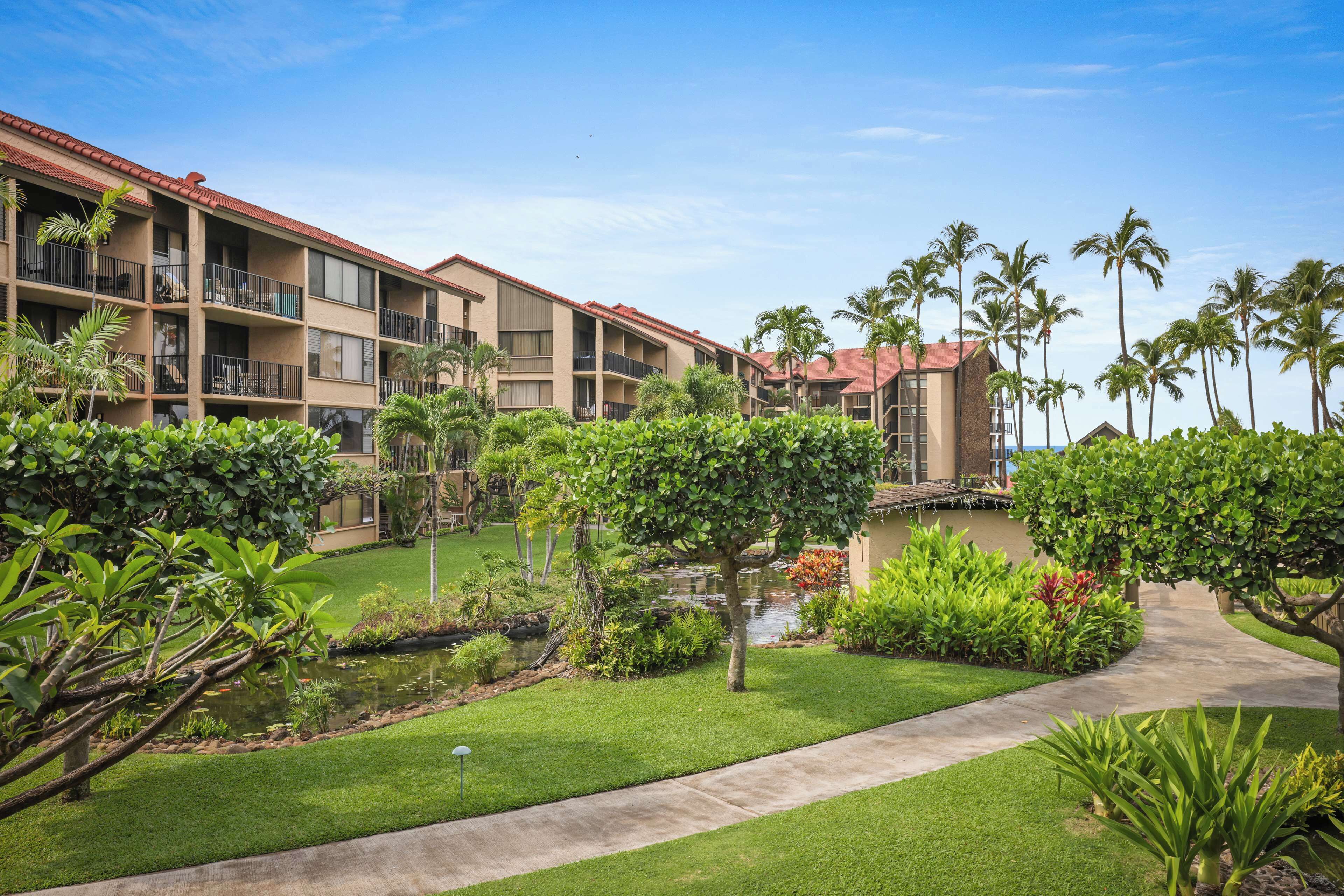 A hotel with multiple floors, outdoor pools, and lush greenery.