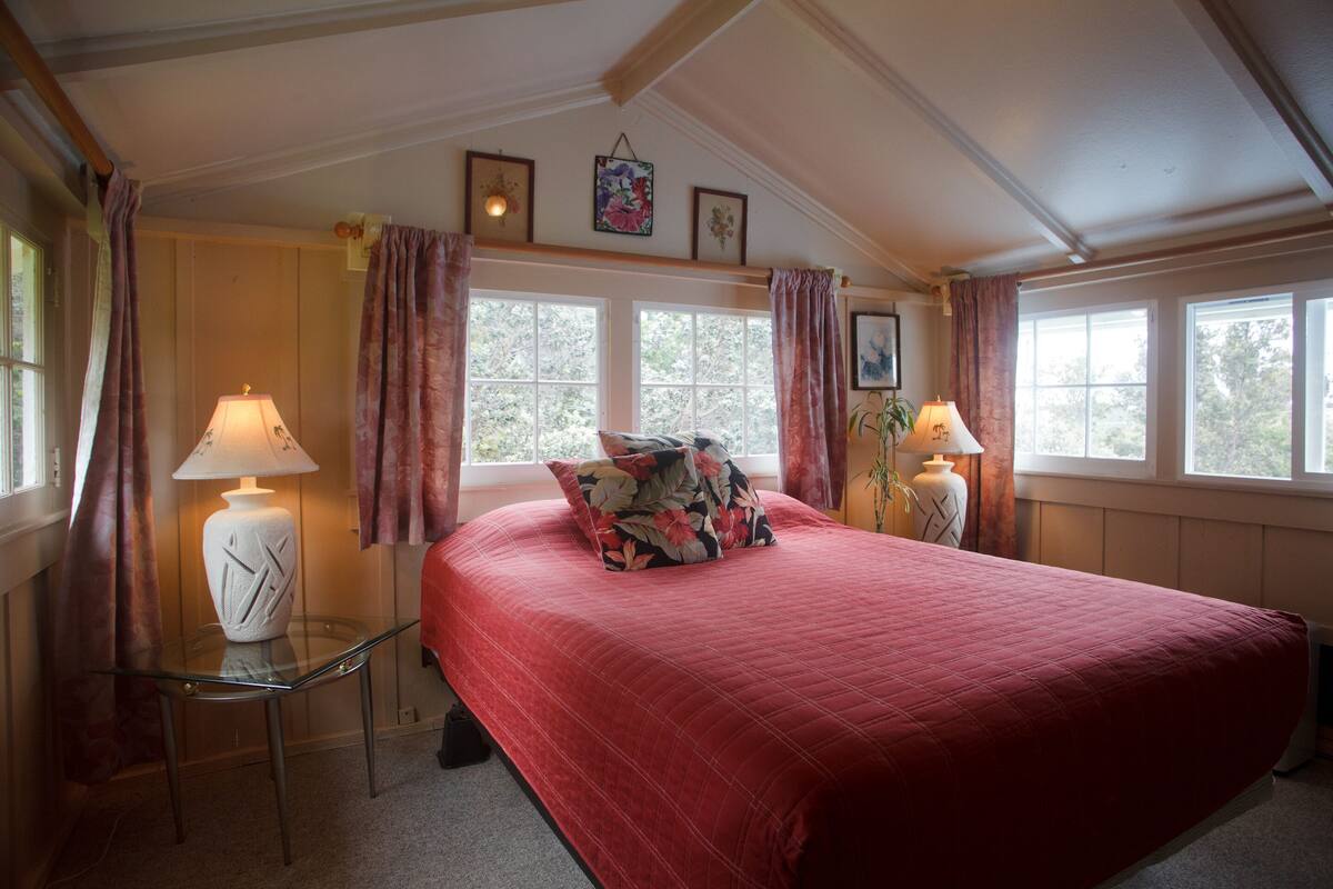Ein Schlafzimmer mit einem großen Bett, zwei Nachttischlampen und einem Glastisch.
