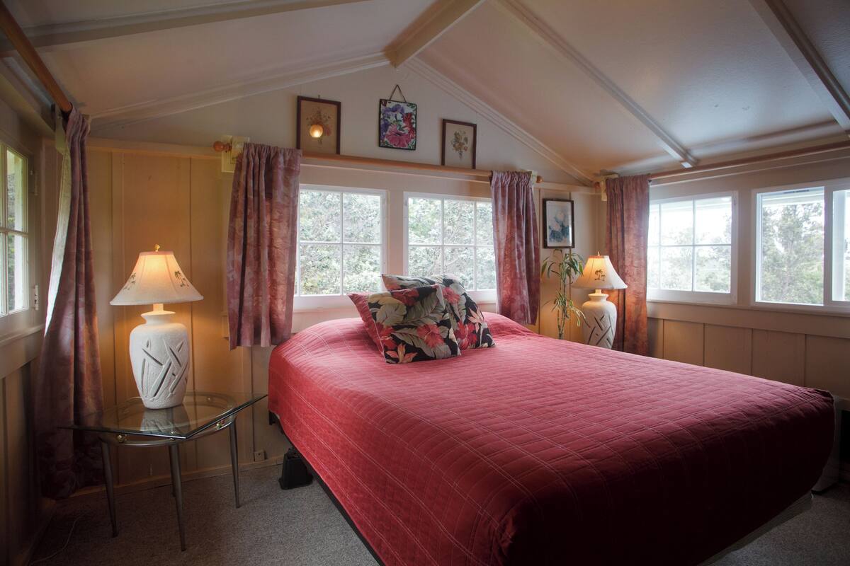 Ein Schlafzimmer mit einem großen Bett, zwei Nachttischlampen und einem Glastisch.