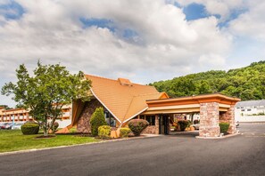 A hotel with a unique sloped roof, brick exterior, and a covered entrance. - Howard Johnson by Wyndham North Plainfield (North Plainfield)