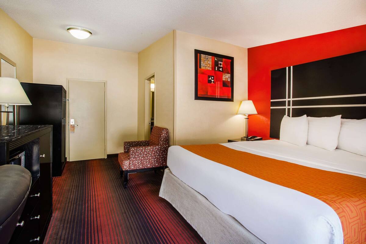 Une chambre d’hôtel équipée d’un lit, d’un bureau, d’une chaise et d’un téléviseur.