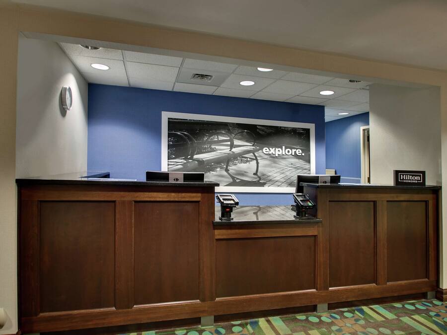 A reception desk with a blue wall and a large framed picture above it.