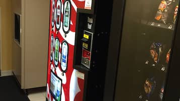 A vending machine with a Coca-Cola logo and a beverage dispenser.