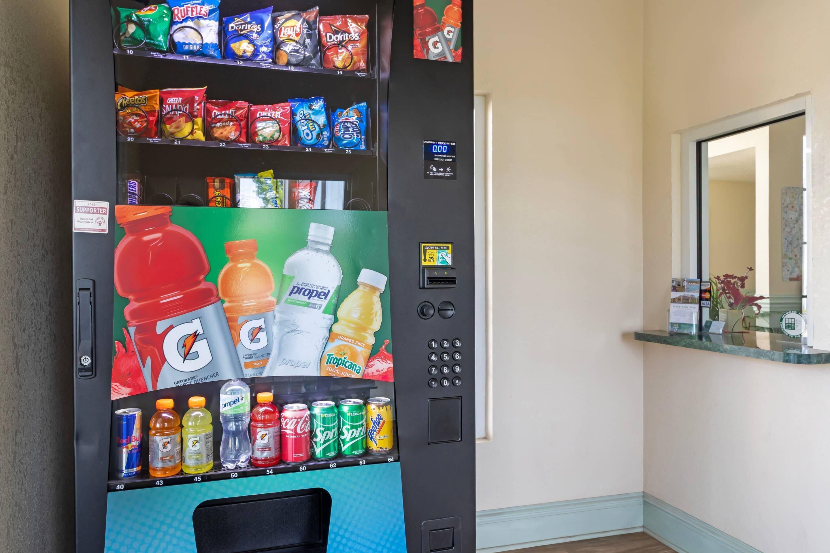 Un distributeur automatique proposant une variété de collations et de boissons, notamment des boissons Gatorade, Tropicana et Sprite.