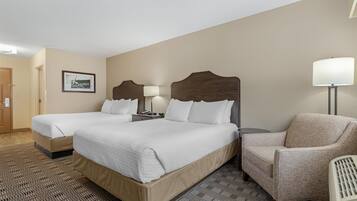 Une chambre d’hôtel avec deux lits, une chaise, une lampe et un panneau accroché au mur.